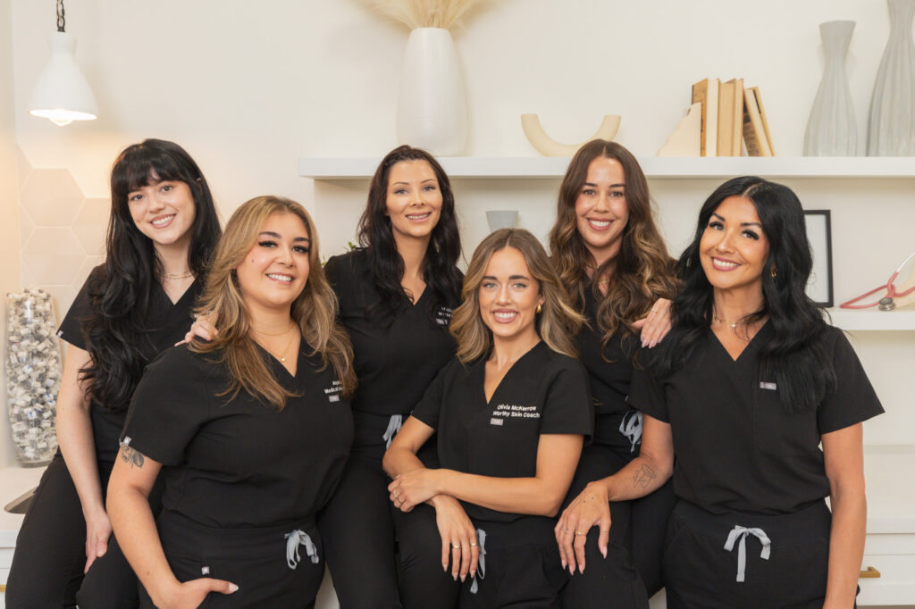 The Worthy team stands together, smiling, ready to help you with tattoo removal before and after you book your appointment.