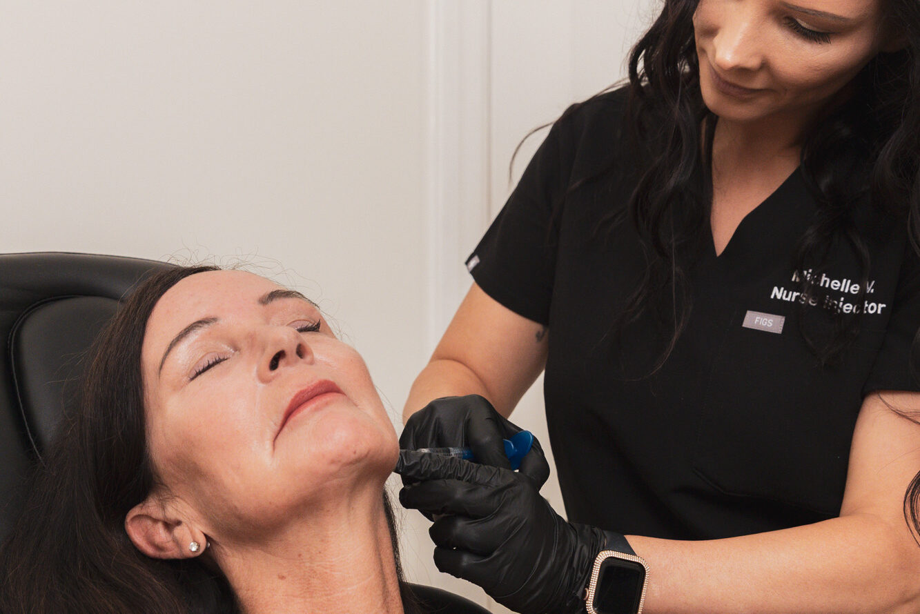 A nurse injector administers a patient's jawline filler, a treatment commonly paired with masseter muscle Botox in Kitchener.