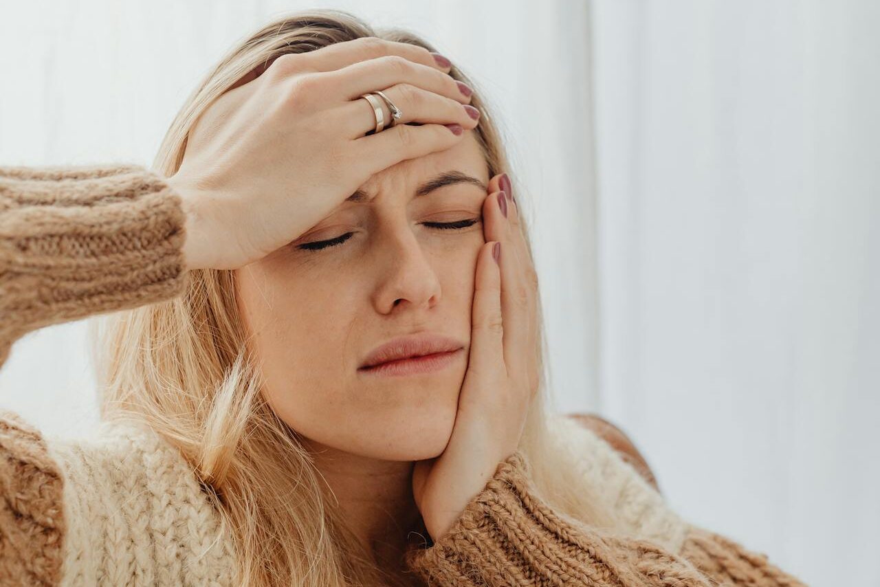 A woman struggles with chronic jaw pain before seeking masseter muscle Botox in Kitchener.